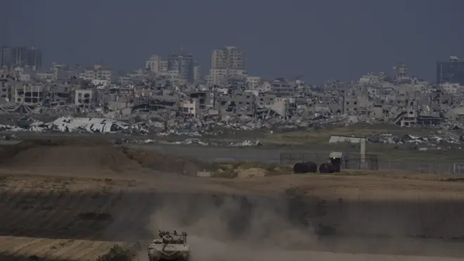 Israeli soldiers move on the top of a tank near the Israeli-Gaza border, as seen from southern Israel