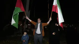 A demonstrator waves Iranian and Palestinian flags during an anti-Israeli gathering at the Felestin (Palestine) Square in Tehran, Iran