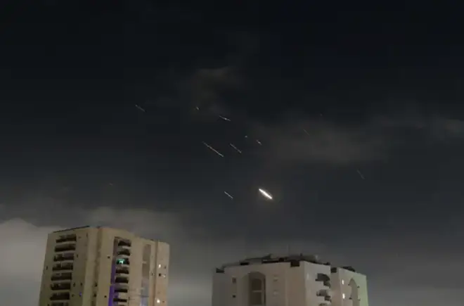 This photo taken on April 14, 2024 shows flares from explosions in the sky over Tel Aviv as Israel's anti-missile system intercepts missiles and drones from Iran