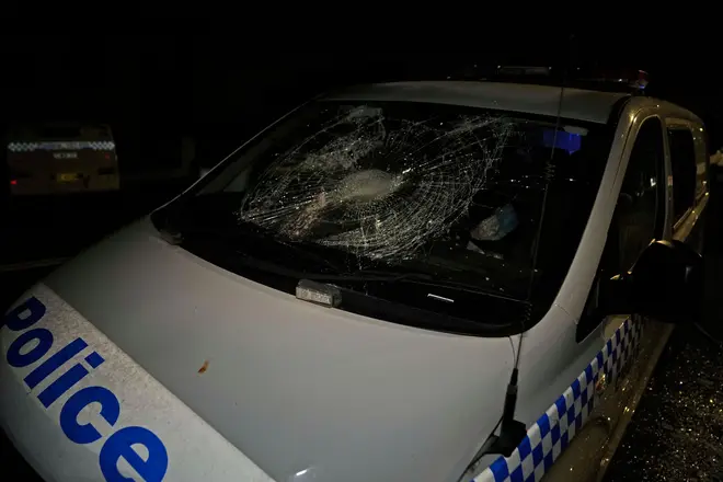 A police car is seen vandalised outside a church where a bishop and churchgoers were reportedly stabbed