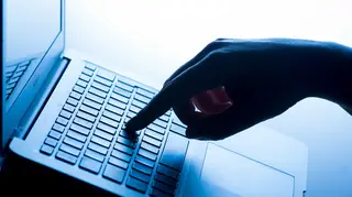 A hand on a laptop