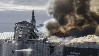 Firefighters work as smoke rises out of the Old Stock Exchange in Copenhagen, Denmark