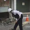 Police officers clean the debris from an earthquake in Uwajima, Ehime prefecture, western Japan