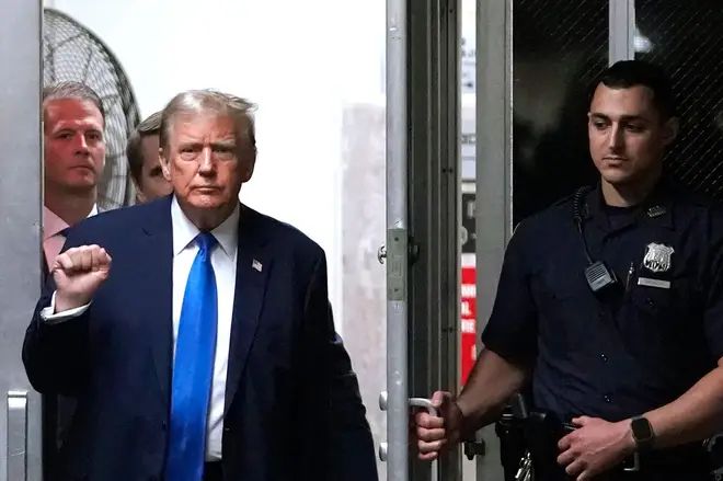 Former President Donald Trump gestures in the hallway outside the Manhattan criminal court in New York