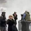 Bystanders react after witnessing the man lighting himself on fire