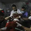 Palestinian medics carry a child hurt in the Israeli bombardment of the Gaza Strip to the Kuwaiti Hospital in Rafah refugee camp