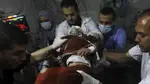 Palestinian medics carry a child hurt in the Israeli bombardment of the Gaza Strip to the Kuwaiti Hospital in Rafah refugee camp