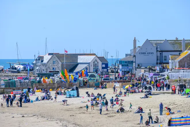 Lyme Regis, Dorset, UK. 20th Apr, 2024. UK Weather: Visitors flock to the beach at the seaside resort of Lyme Regis to enjoy the glorious warm sunshine and clear blue skies. Credit: Celia McMahon/Alamy Live News.