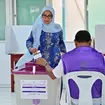 A woman casts her vote at a polling station in Male
