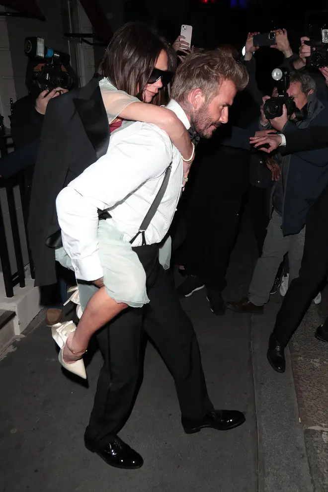 David Beckham carrying wife Victoria who recently suffered a broken foot