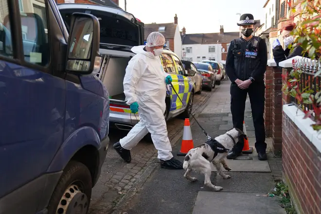 Forensic officers entry the property with a police dog in Moore Street, Kingsley, Northampton following a discovery of a body in a rear garden