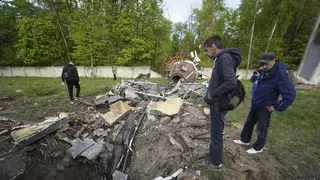 People look at fragments of the television tower which was hit by a Russian missile in Kharkiv