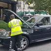 An AA patrol works on a car