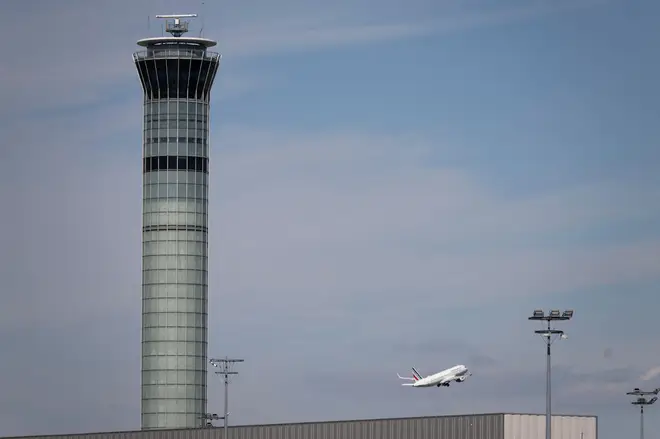 An Air France airliner takes off behind the control tower at Roissy-Charles de Gaulle airport