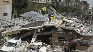 A man stands on a house that was destroyed by an Israeli airstrike, in Hanine village, south Lebanon