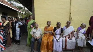Elderly voters sit as others stand in a queue to vote during the second round of voting in the six-week-long national election near Palakkad, India