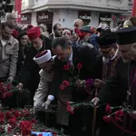 Representatives of the Turkish communities put flowers over a memorial placed on the spot of an explosion on Istanbul’s popular pedestrian Istiklal Avenue
