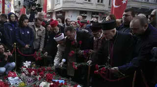 Representatives of the Turkish communities put flowers over a memorial placed on the spot of an explosion on Istanbul’s popular pedestrian Istiklal Avenue