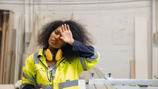 Black female model portraying a tired factory worker