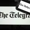 The logo of The Telegraph newspaper displayed on the screens of a tablet and a smartphone