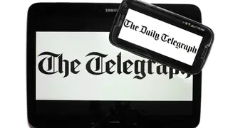 The logo of The Telegraph newspaper displayed on the screens of a tablet and a smartphone