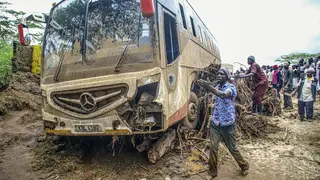 People try to move a bus that was washed away in Kenya