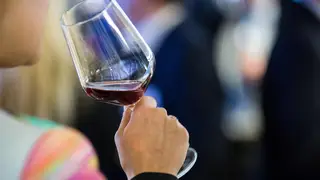 A woman drinking wine at a business function