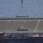 A crane loads food aid for Gaza onto a container ship docked in Cyprus