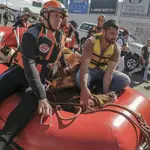 Firefighters use a raft to transport a horse after rescuing it from a roof, where it was trapped for days amid flooding, after heavy rain in Canoas, Rio Grande do Sul state, Brazil