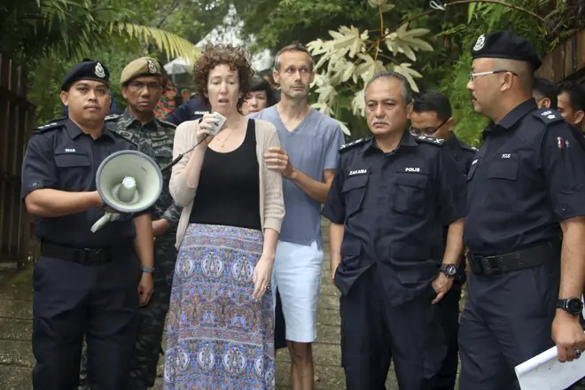 Meabh Quoirin, center left, the mother of a missing British girl Nora Anne Quoirin, speaks to police officers as father Sebastien Quoirin, center right, stands beside her, in Seremban, Negeri Sembilan, Malaysia