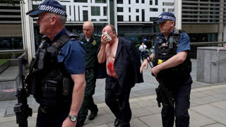 An injured man is led away from the Home Office