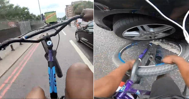 The cyclist doing a wheelie got his bike trapped under the Mercedes