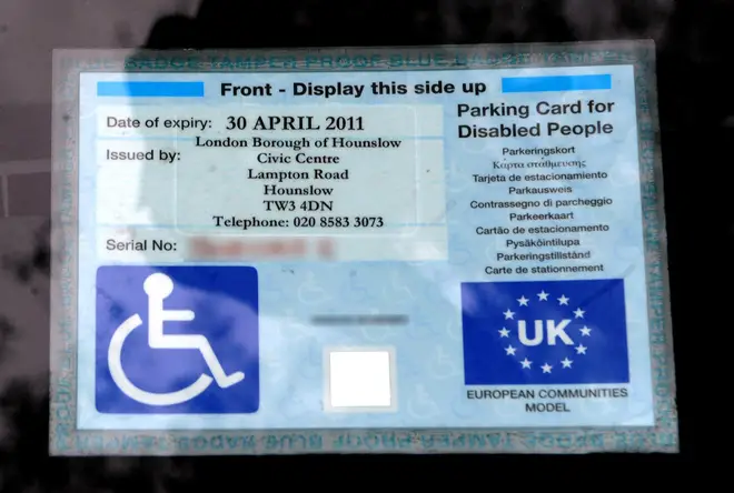 A disabled parking badge is displayed at a Sainsburys store in London.