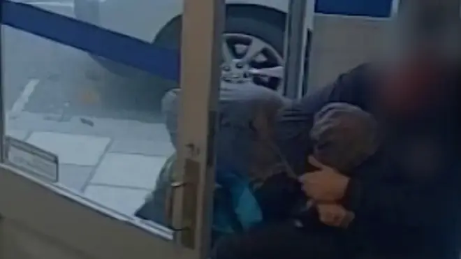 Hero gets bank robber in a headlock