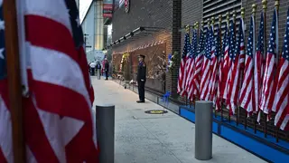 New York City firefighters stand to attention in front of a memorial during a ceremony commemorating the 18th anniversary of the terror attack.