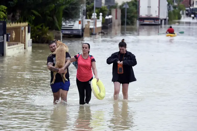 People walk along a flooded road after heavy raining in El Raal, near Murcia, Spain.