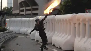 An anti-government protester throws a Molotov cocktail during a demonstration near Central Government Complex in Hong Kong.