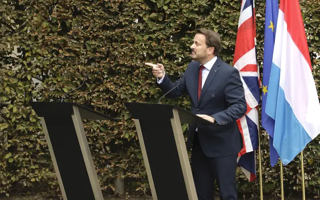 Luxembourg's Prime Minister Xavier Bettel, right, addresses a media conference next to an empty lectern intended for British Prime Minister Boris Johnson.