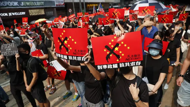 Protesters hold up anti-Chinese Government signs