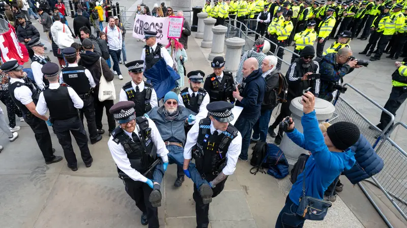 A protester is being arrested by the police for holding a placard reading "I oppose genocide, I support Palestine Action" during the rally.