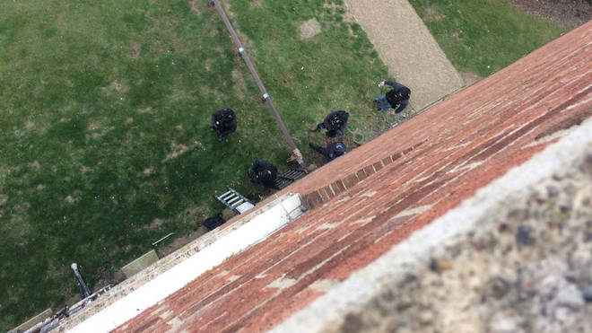 Officers were seen leaning ladders against the block of flats