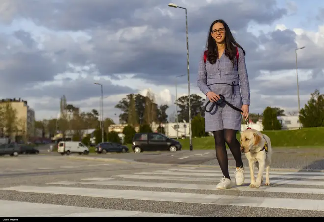 A woman walking her guide dog