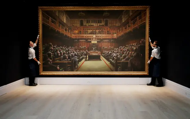 Sotheby's gallery assistants handling Banksy's Devolved Parliament painting