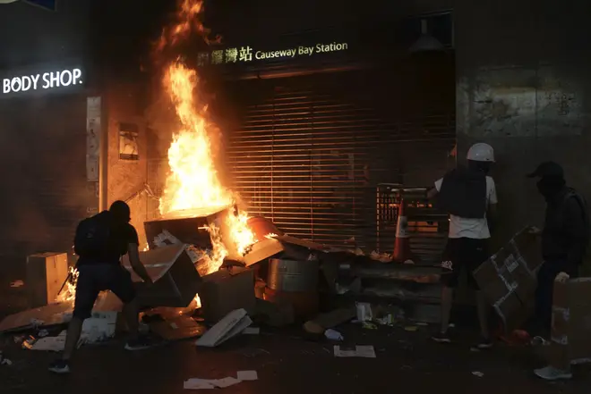 Protesters set cardboard boxes on fire at the entrance to the Causeway Bay Subway station in Hong Kong