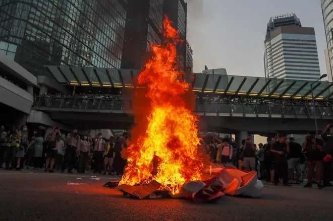 Protesters burn a China 70th anniversary celebration banner in Hong Kong