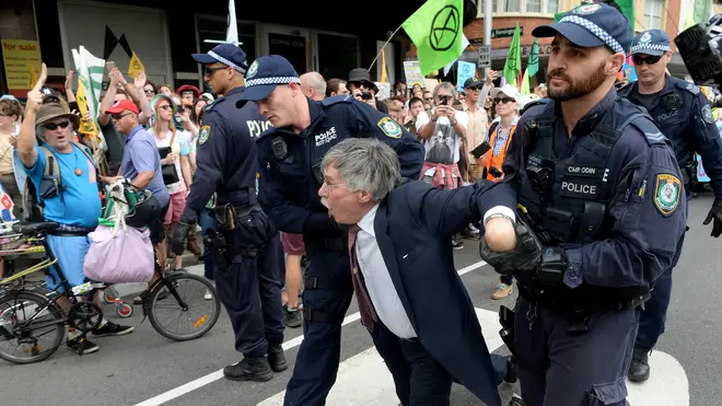 A man in a suit was dragged away by police in Sydney