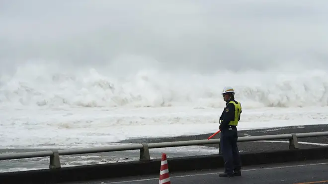 An official looks on at high seas caused by the typhoon
