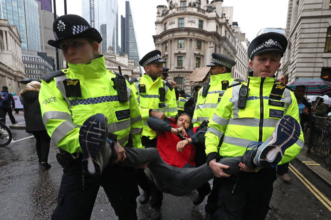 A protester is carried away as others continue to block the road outside Mansion House in the City of London, during a climate change protest.