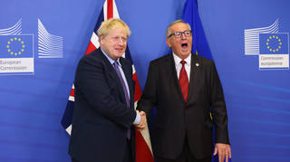 Boris Johnson and European Commission President Jean-Claude Juncker shake hands as they meet the press during an EU summit in Brussels