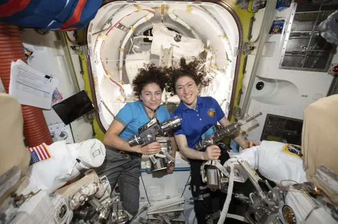 Astronauts Jessica Meir, left, and Christina Koch pose for a photo in the International Space Station